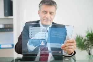 Businessman using futuristic touchscreen to view social network profile 
