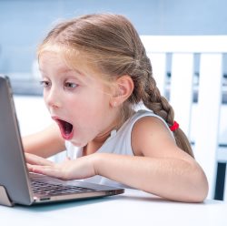 astonished little girl with her computer