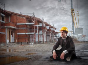 businessman wearing a helmet and sitting in a construction site