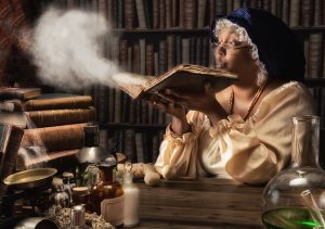 Medieval alchemist blowing dust off the old books in her laboratory