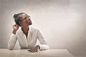 woman leaning on desk thinking woman leaning on desk thinking