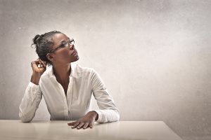 woman leaning on desk thinking