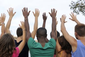 Diverse volunteer group raising hands