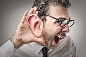 businessman with abnormally large ear trying to hear
