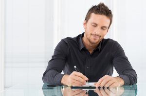  Businessman Writing a Paperwork at Office