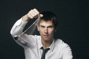 Businessman holding a pocket watch and swinging it in the fashion of a hypnotist