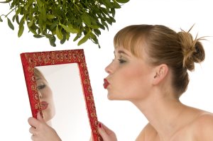 Model Kissing Herself In A Mirror Under Mistletoe