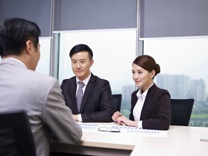 businessman and businesswoman talking to boss in office