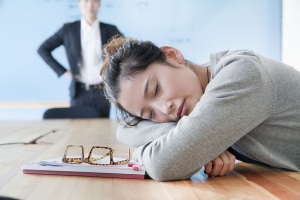 Young businesswoman sleeping during meeting, disappointed Boss looking at her
