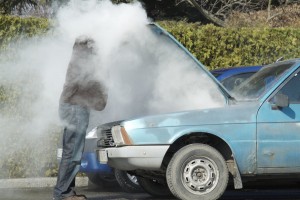 Man looking at a smoking engine in his car