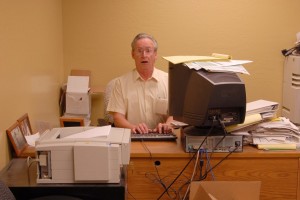 stressed out man at computer with messy desk