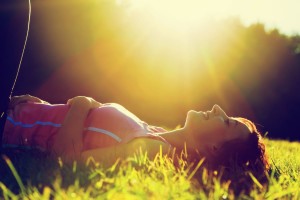 woman lying on the grass at summer sunset