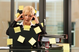 woman stressed in office with post-its stuck all over her