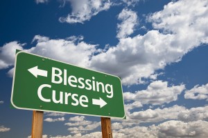 Blessing, Curse Green Road Sign Over Dramatic Blue Sky and Clouds