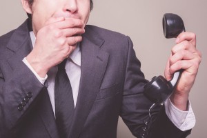 Businessman On Phone Covering His Mouth