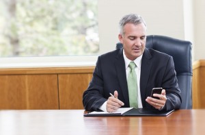 Businessman reading text messages on his phone
