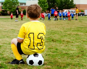 child in uniform watching organized youth soccer