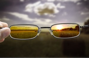 out of focus nature at sunset with hand holding glasses