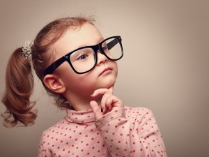 Little girl with big glasses thinking