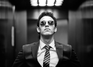 Black-and-white portrait of an ambitious business guy wearing sunglasses