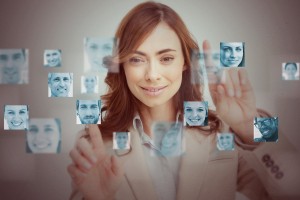 Businesswoman touching digital interface showing human faces