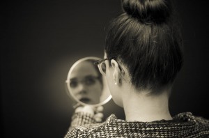 Woman Looking At Self Reflection In Mirro