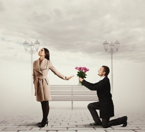 angry young woman rejecting man with flowers